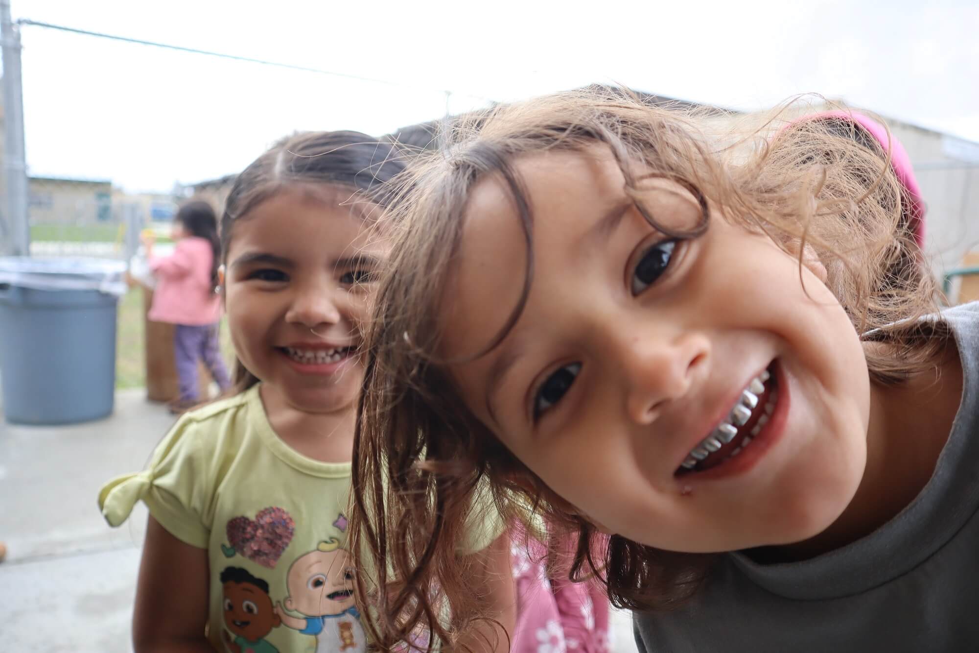 Two young children happily looking at the camera